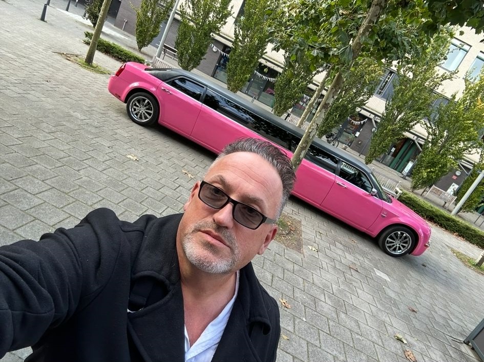 Roze limousine met Frans de chauffeur